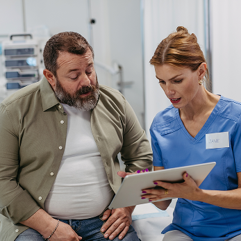Actor portrayal of a doctor and patient discussing triglyceride levels in a doctor's office.