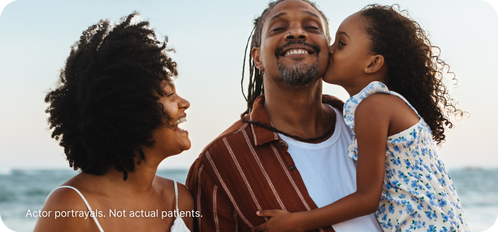 Actor portrayal of parents with their child on the beach.